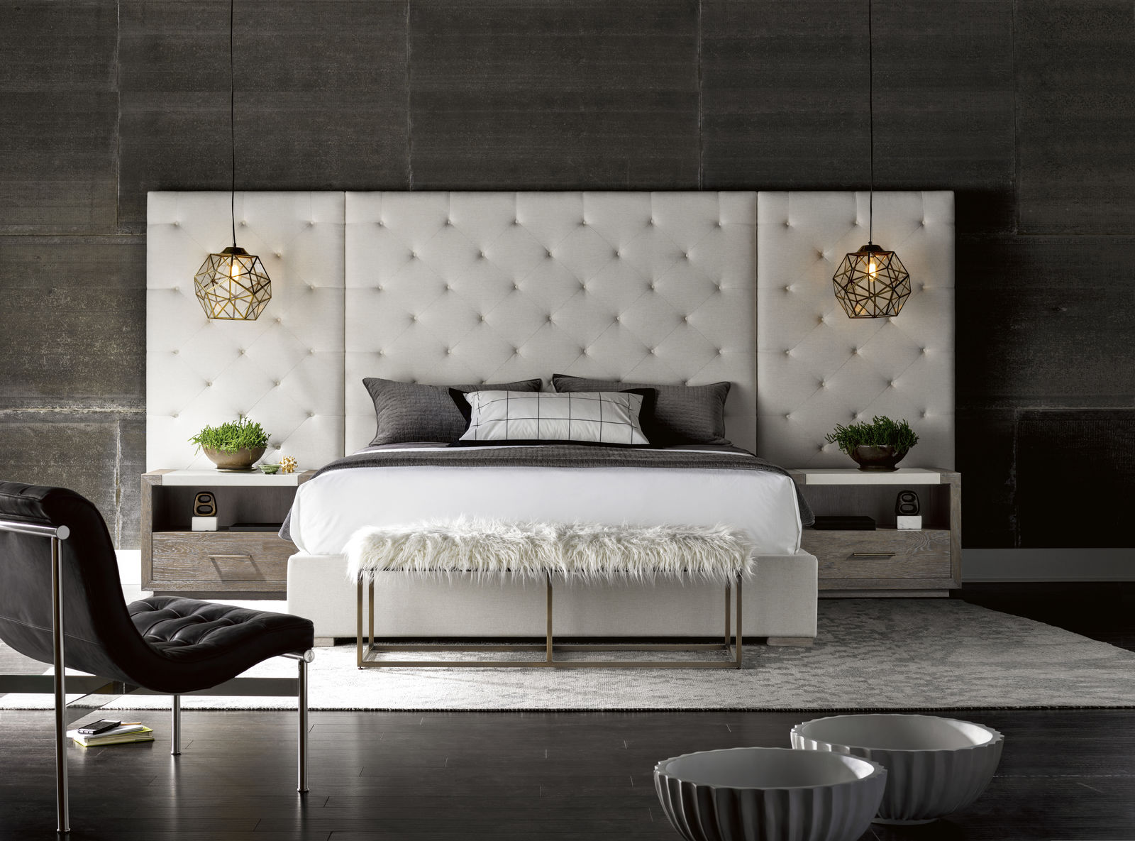 White upholstered bed with gold pendant lights, nightstands and a bench