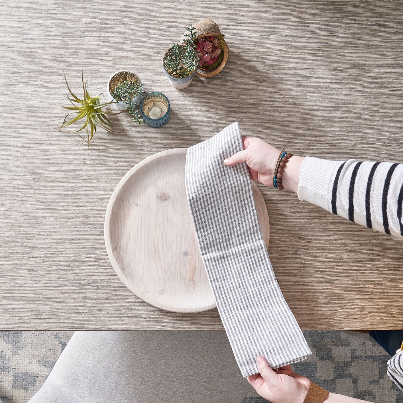 Image of greenery, linen and charger on a dining room table