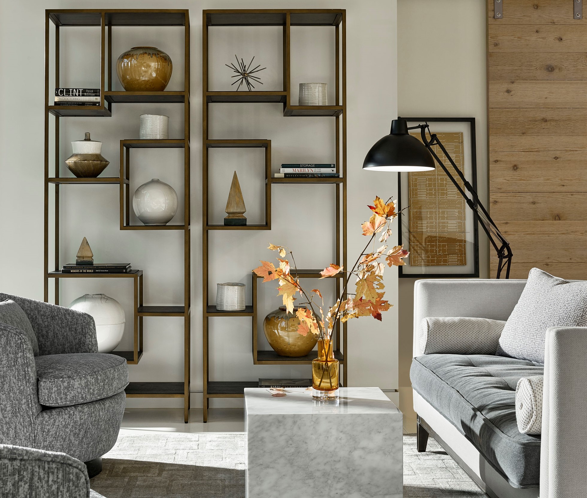 living room with a coffee table that has a vase filled with orange branches on top of it