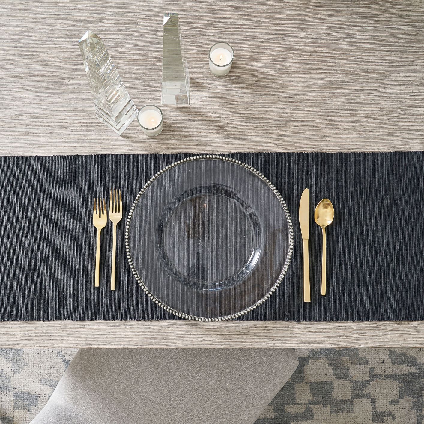 table with black tablecloth, plate and gold flatware