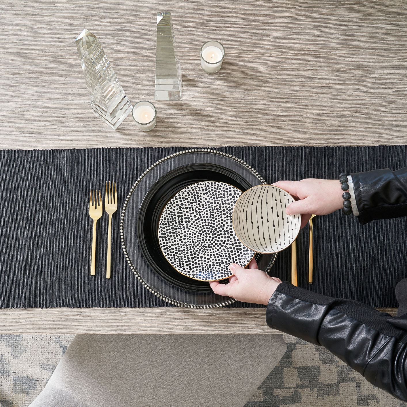 table with black tablecloth, plate, gold flatware, and patterned bowls
