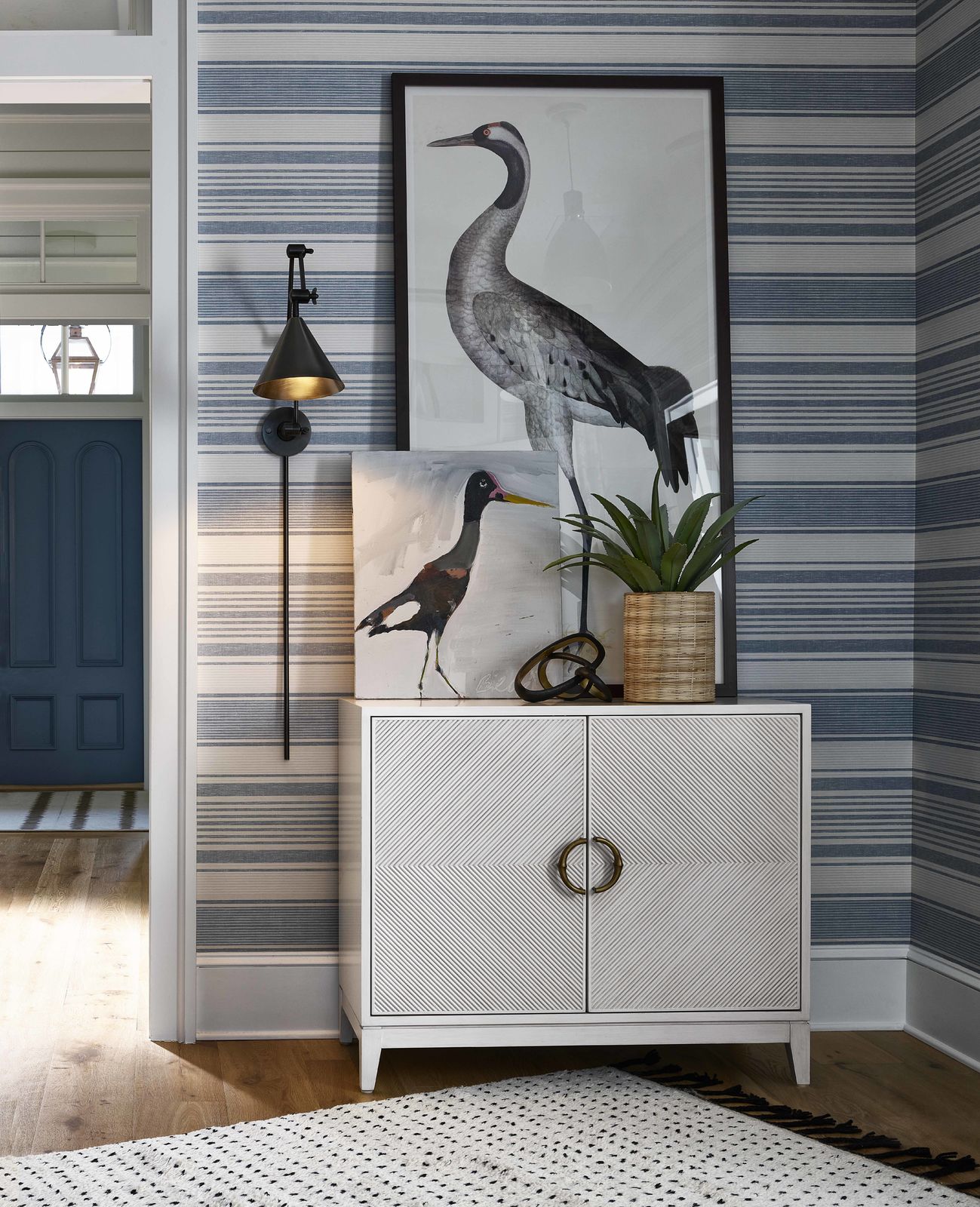 striped wallpaper and chest with bird artwork on top